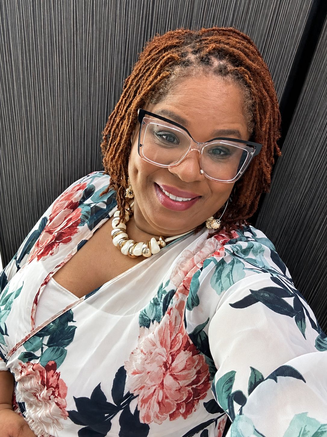 Kemi Miller in a white floral wrap top, smiling